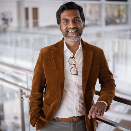 Man smiling with arm on banister.