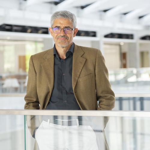 Man standing with hands in pockets.