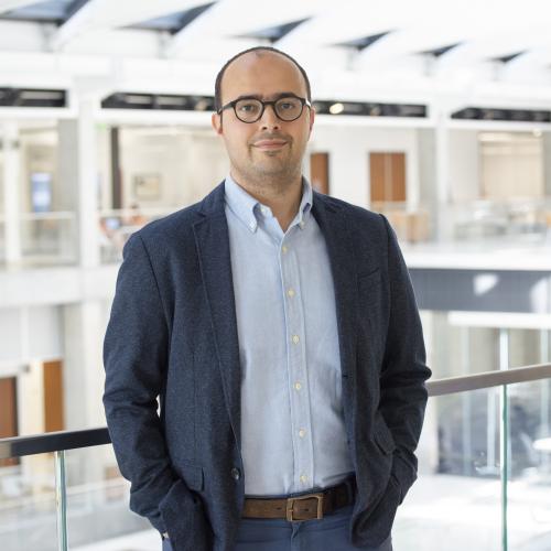 Man standing with hands in pockets.