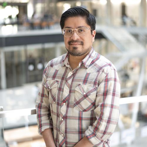 Main in glasses in front of railing.